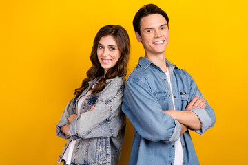 Photo of two cheerful nice people crossed hands beaming smile isolated on yellow color background