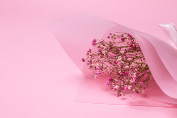 Delicate dry pink flowers. Small flowers. On a pink background. Spring, feminine, cute. Pink background. Flowers. Dried flowers. Empty space. Bouquet.