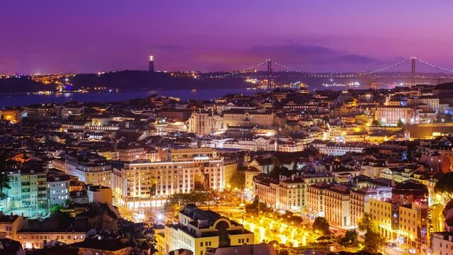 Timelapse of Lisbon famous view from Miradouro da Senhora do Monte tourist viewpoint over Alfama old city district, 25th of April Bridge in the evening twilight. Lisbon, Portugal. Camera pan effect
