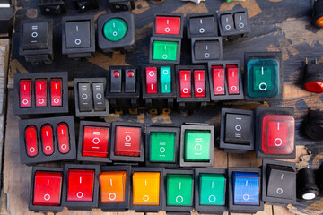 Top view. Fragment of mechanism. Green, yellow, black and red button for turning on an electrical...