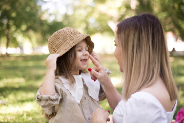 Mom touches the baby's nose and girl smiling