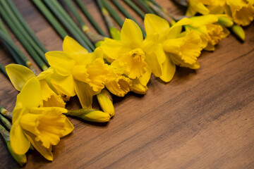 Daffodils narcissus Easter composition laying on a wooden board table, close up