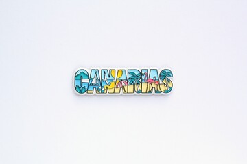 Colourful PVC souvenir fridge magnet of Canary Islands on white background. Travel memory concept. Gift typical product for tourists from foreign trip. Home decoration. Top view, flat lay, close up