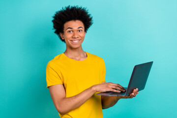 Photo of positive cheerful handsome guy dressed casual t-shirt typing email on laptop remote work...