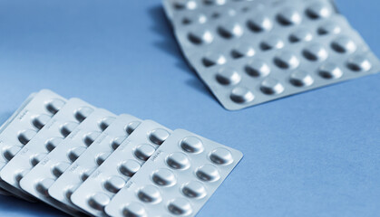 Different blister of pills. Medical healthcare concept. Light blue paper background with copy space.