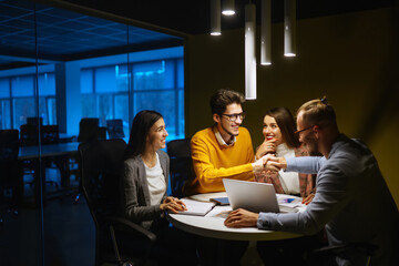 Workaholics businesspeople brainstorming financial company ideas analyzing strategy paperwork late at night in business office.Business Partners Discuss Financial Reports, Plan Investment Strategy.