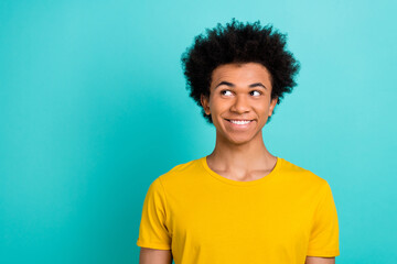 Obraz na płótnie Canvas Portrait of friendly good mood guy with afro hairdo wear yellow t-shirt look at sale empty space isolated on shine teal color background