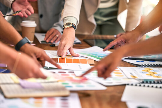 Creative meeting, color and hands of business people on desk for branding logo, strategy and marketing design. Teamwork, collaboration and designers brainstorming ideas, thinking and planning project