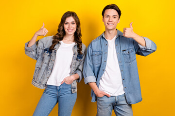 Fototapeta premium Photo of attractive girl handsome guy toothy smile demonstrate thumb up approval isolated on yellow color background