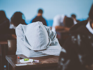 Tired uniform students sleeping in a exam test in classroom with stress