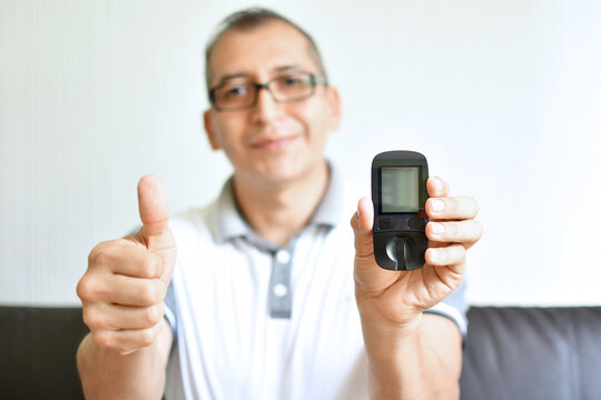 Hombre latino feliz con el resultado de su prueba para medir az&uacute;car en la sangre.