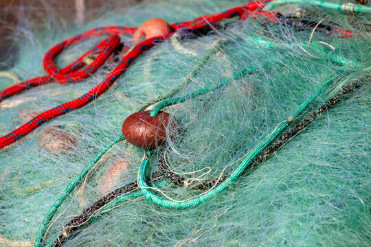 reti da pesca accatastate ad asciugare in bidoni 