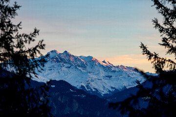 Sunset in the winter in the swiss alps with snow covered mountains in the region of Graubünden, Switzerland