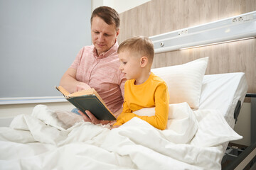 Gorgeous father is demonstrating something to the child in the hospital