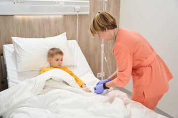 Child with catheter in hand receiving qualified service in the medicine center