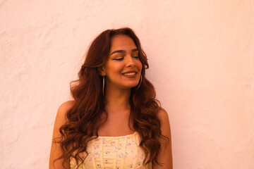 Fototapeta premium Beautiful young woman with long curly hair on a white background makes different expressions. Laughter, hate, sadness, smile, tired, admiration, surprise, happiness. Concept different expressions.