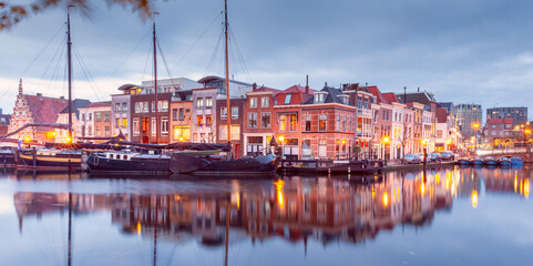 Beautiful old houses on the city embankment of Leiden at sunset.