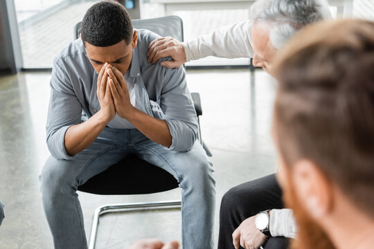 Depressed African American Man Sitting In Group During Alcoholics Meeting In Rehab Center.