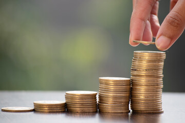 Small investments in mutual fund, hand putting coin stack