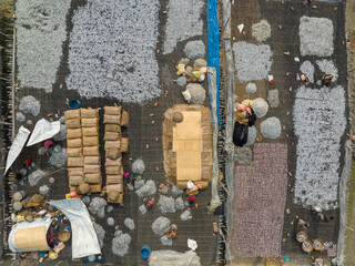 Aerial view of people working in a fishing farm drying seafood along Karnaphuli river, Patiya, Dhaka, Bangladesh.