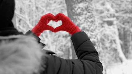 I Love  - A woman is holding her gloved hands in the shape of a heart - Black and white photo where only the gloves are red