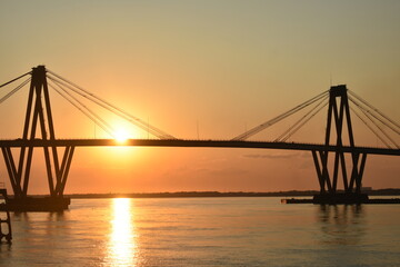 Fototapeta premium Puente de Corrientes, Argentina, fotografía paisaje, lancha pasando, atardecer