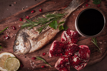 Fried dorado fish, with spices and herbs, on a wooden board, pomegranate sauce, close-up, no people,