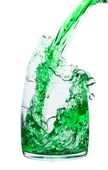 Green drink is poured into a transparent glass