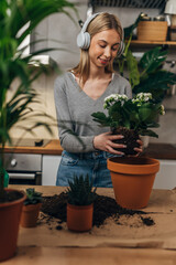 Young woman potting a plant at home