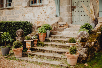 Fototapeta na wymiar Les marches et pot de fleurs à l'entrée de la maison ancienne 