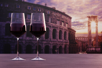 Glass of two red wine with view of sunset over Rome Colosseum in Rome, Italy