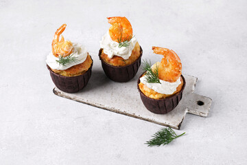 three savory muffins with shrimps and cheese on gray background, copy space