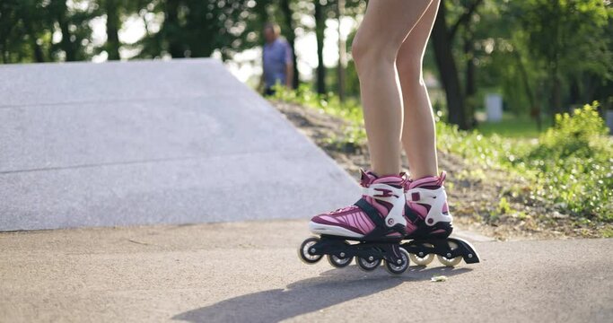 Skater girl does tricks on roller skates in park