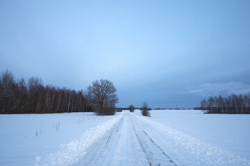 Fototapeta na wymiar Sunset on a snowy road. Off-road on a snow-covered road.
