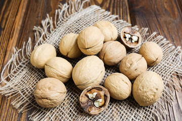 Whole walnuts on a wooden background.