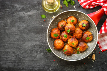 Meatballs in tomato sauce with herbs in frying pan. Top view with copy space.