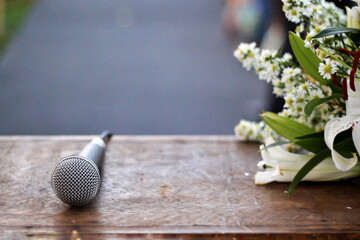 a beautiful altar table from a wedding with a microphone on top and an arrangement of white flowers...