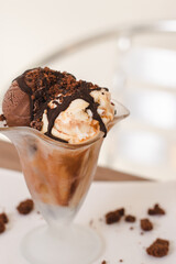 Top view of a cup of chocolate and vanilla ice cream with chocolate coating.