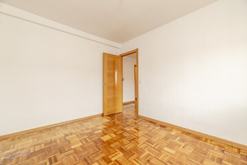 A room with lsio white painted walls, parquet floors made of oak slats laid out in a checkerboard...