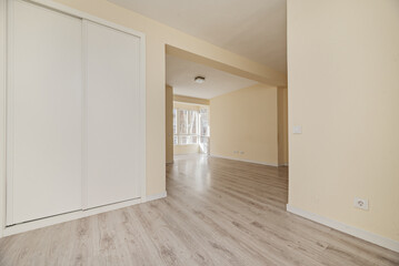A room with irregular walls with a built-in wardrobe with white sliding doors in one of them