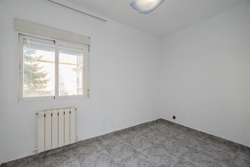 room with aluminum windows with glass, walls with white paint with drip, aluminum radiator, and gray stoneware floors