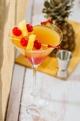 Bikini martini cocktail in martini glass garnished with cherries and pineapple. Martini alcoholic cocktail or non-alcoholic mocktail. Martinis.