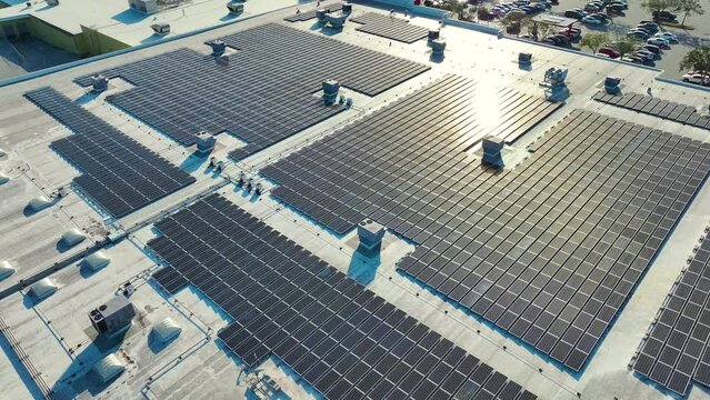 Electric photovoltaic solar panels installed on shopping mall building rooftop for production of green ecological electricity. Concept of producing sustainable energy