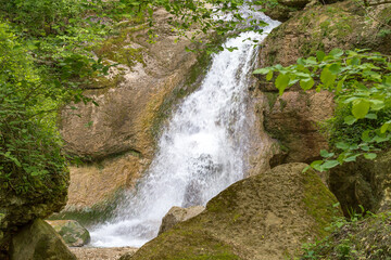 waterfall, cascade of a mountain river in a stone bed, summer season,panoramic view.