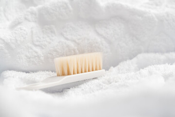 Baby hair brush on white background with towel. Baby bath and hygiene concept