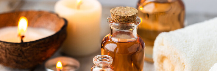 Concept of spa treatment in salon with pure organic natural oil. Atmosphere of relax, detention. Aromatherapy, candles, towel, wooden background. Skin care, body gentle treatment