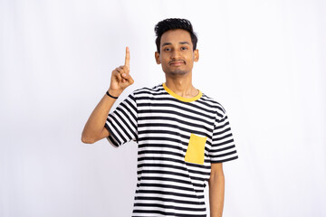 Fototapeta premium Handsome man Pointing up fingers looking and smiling at the camera on the white wallpaper Background
