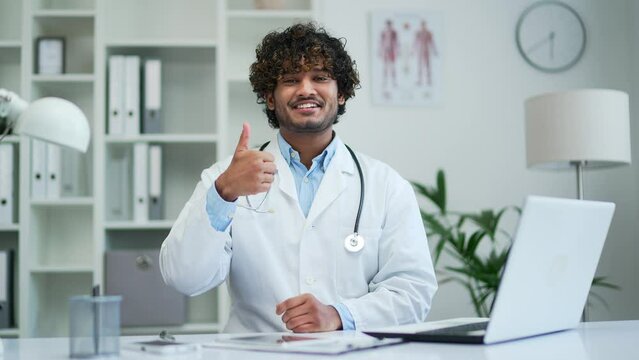 Doctor doing happy giving thumbs up gesture Approving expression looking at the camera with showing success symbol of agreement and trust Confident expert therapist recommends webcam view