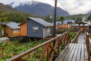 Small colorful houses and nalca plants along the wooden paths of Tortel, Patagonia, Chile