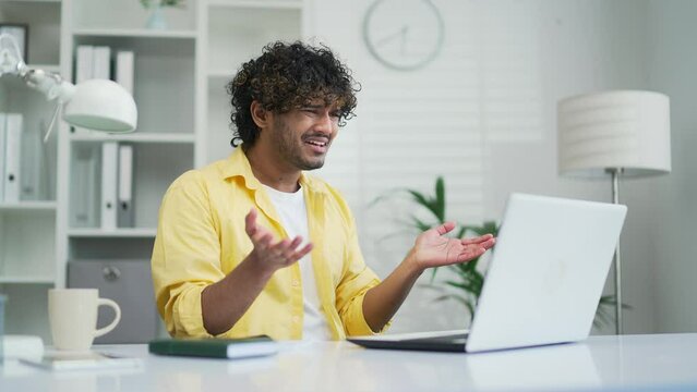 Shocked young office worker or freelancer reading bad news looking at laptop computer Male receives a message with a negative result Stressed man looking at screen confused by problem or crash
